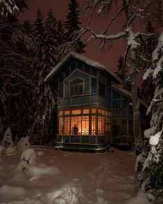 a cabin lit up at night in the snow