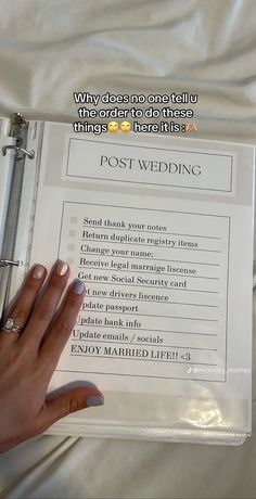 a person's hand holding a ring binder over a white sheet with the words post wedding written on it