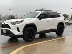 a white toyota rav parked in a parking lot