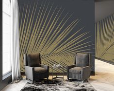 two chairs and a table in front of a wall with palm leaves painted on it