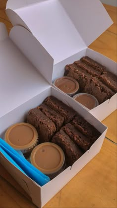 two open boxes filled with brownies on top of a wooden table