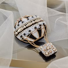 a black and white purse with pearls on it's side sitting on a table