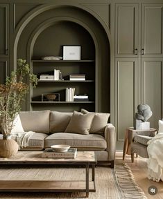 a living room filled with furniture and a book shelf in the back wall behind it