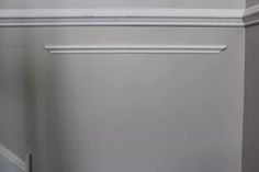 the corner of a room with a door and some white trim on it's walls