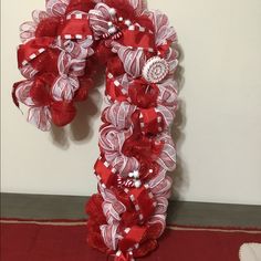 a red and white ribbon wreath on top of a table