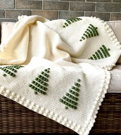 a knitted blanket sitting on top of a wicker couch