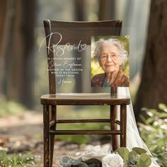 an old woman's portrait on a chair with flowers and greenery around it