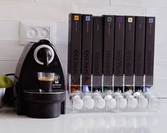 an espresso machine sitting on top of a counter next to several stacks of books