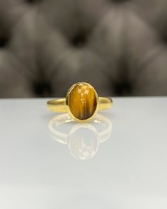 Natural Tiger Eyes Ring * Dainty Cabachon Ring * Genuine Tiger Eyes & 14K Solid Gold * Best Gift for Her/Him * Handmade Ring ◎ Details ◎ ○ Gemstone Details .Natural TIGER EYES Oval Cut 10x8 mm approx. 2.00 ct ○ Gold Details 14K Solid Gold Width of Band : 2.50 mm Weight of Ring : approx 3.80 gr Made to Order HANDMADE ITEM ○ Upgrade to Solid 18K Gold, please click the link below: https://www.etsy.com/listing/962826004 For more CABACHON BEZEL rings : http://etsy.me/37fvI60 All of our jewellerie 14k Yellow Gold Cabochon Ring, Luxury Oval Cabochon 14k Stamped Rings, Luxury 14k Stamped Oval Cabochon Ring, Luxury Stamped 14k Oval Cabochon Ring, Handmade 14k Gold Oval Rings, 14k Gold Cabochon Rings With Round Band, 14k Gold Cabochon Ring With Round Band, 14k Yellow Gold Oval Cabochon Birthstone Ring, Sterling Silver Yellow Gold Oval Cabochon Rings