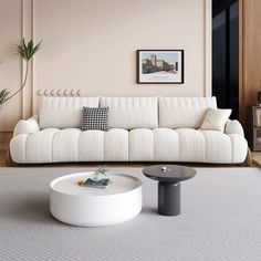 a living room with a white couch and coffee table in front of the wall,