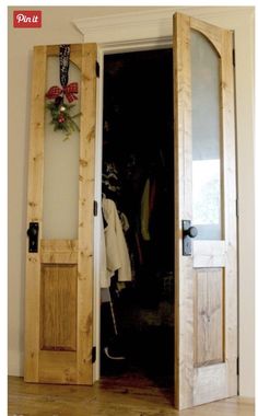 an open wooden door with clothes hanging on it