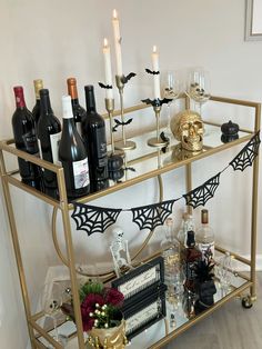 a gold bar cart filled with bottles and glasses