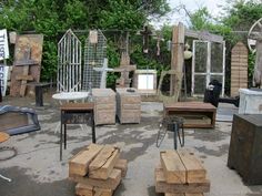 an outdoor area with several pieces of furniture on the ground and trees in the background