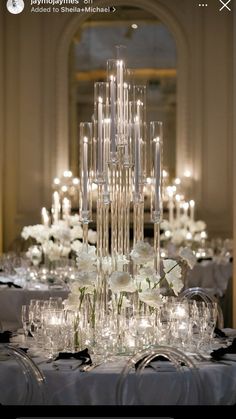 an elegant table with white flowers and candles