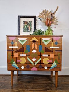 a wooden cabinet with geometric designs painted on it