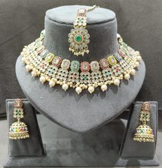 This Beautiful and bold choker with earrings and tikka is the perfect pop of color for any outfit. It comes in multi color stones and can be paired with almost anything as all the colors are on the jewelry itself. Wear it with neutral clothes for a pop of color or with bright clothing to stand out with a statement look! The jhumka and tikka are gorgeous and can be paired separately as well! Traditional Multicolor Multi-stone Jewelry Set, Fusion Style Multicolor Kundan Necklace For Party, Party Style Fusion Multicolor Kundan Necklace, Party Multicolor Fusion Kundan Necklace, Party Fusion Style Multicolor Kundan Necklace, Multicolor Multi-stone Bridal Necklace For Festive Occasions, Multicolor Bridal Necklace For Party, Fusion Style Multicolor Bridal Necklace For Party, Bollywood Style Multicolor Sets With Tilla