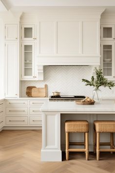 a kitchen with white cabinets and wooden stools