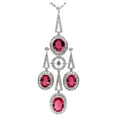 This eye-catching Art Deco style necklace features a beautiful collection of sparkling rubellite tourmaline ovals weighing 14.23 carats total! Over 3.50 carats of brilliant, pave-set diamonds frame the bright pink gems and adorn the various shapes that come together to form this elegant piece. Crafted in 18k white gold, this gorgeous pendant measures approximately 3 inches in length. With the included 18-inch, 18k white gold chain, the bottom of the pendant will sit where a 24-inch chain would s Art Deco Diamond Pendant, Rubellite Tourmaline, White Gold Chain, White Gold Sapphire, Pink Gem, Drop Pendant Necklace, Tourmaline Necklace, Modern Necklaces, Ring Pendant Necklace