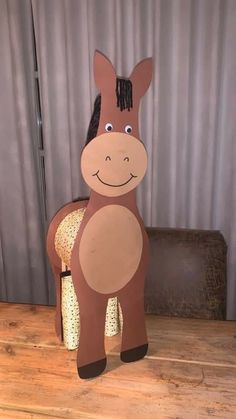 a cardboard horse sitting on top of a wooden table