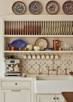 a kitchen with plates and cups on the shelves