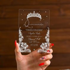 a woman's hand holding up a clear card with a tiara on it