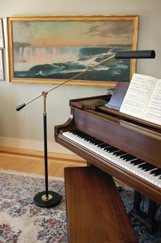 a grand piano in a living room with a microphone and music stand on the floor