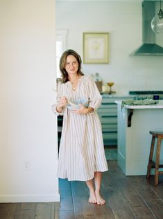 a woman standing in a kitchen holding a bowl