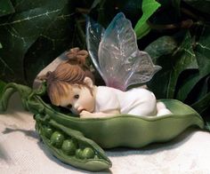 a figurine in a pea pod with a fairy on it