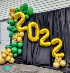 balloons and streamers are arranged in the shape of numbers on a black backdrop that reads 2012