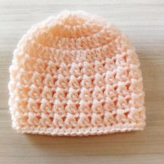 a crocheted hat sitting on top of a wooden table