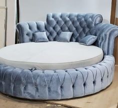 a round blue couch sitting on top of a wooden floor