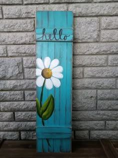 a painted wooden sign with a flower on it