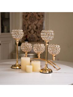 candles are sitting on a table with gold holders