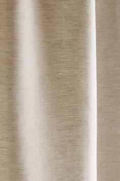 a close up view of a curtain with white fabric on the bottom and tan curtains behind it