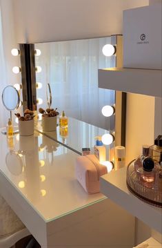 a vanity with lighted lights and bottles on the counter top in front of a mirror