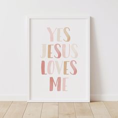 a white framed print with the words yes jesus loves me in pink and gold on it