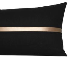 a black pillow with a gold stripe on it