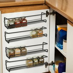 an organized spice rack in the corner of a kitchen