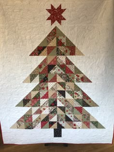 a quilted christmas tree is hanging on the wall