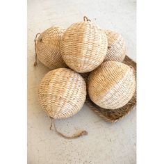 four wicker balls in a basket on the floor