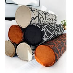 four round cushions stacked on top of each other in different colors and patterns, along with an orange cushion