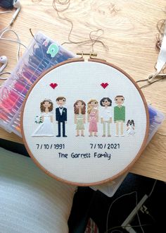 the cross stitch family is on display next to some sewing needles and thread spools