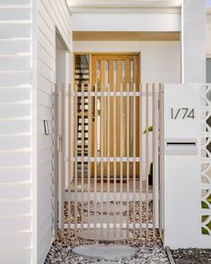 a white house with a wooden gate and mailbox