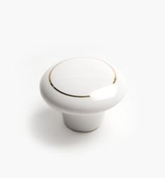 a white door knob with gold trim on the top and bottom, against a white background