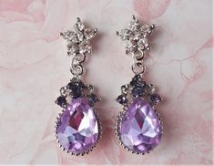 "Elegant, opulent, and shimmery These fabulous vintage inspired earrings can be worn in many occasions. The classic style make these earrings timeless. This brilliant classic earrings features Swarovski lavender amethyst crystal teardrop, surrounded by tiny diamond cut crystals. Crystals are set on a secure prong settings, made of brass and plated in silver. Hanging from a surgical steel post top, it measures 2\" in length. Earrings are light weight and sway gracefully as you move about your day Dangly Purple Earrings, Vintage Earrings Victorian, Vintage Inspired Earrings, Dragon Earrings, Jewelry Photoshoot, Jeweled Earrings, Crystal Dangle Earrings, Classic Earrings, Purple Earrings