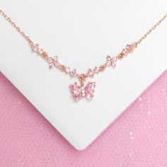 How adorable! The Flutter Love Necklace features an eye-catching baby pink butterfly in between a chain of enchanting CZ flowers. This piece radiates lustrous pink shimmers that are sure to amaze. You'll want to grab this one before it's too late! 18k gold, 18k rose gold or rhodium plated over brass with a protective coating Cubic zirconia stones 15" + 2" extension, 7mm pendant drop Shop our entire In the Garden Collection here Pink Wedding Necklace, Cute Pink Necklaces, Pink Butterfly Jewelry, Aesthetic Pink Accessories, Pink Butterfly Necklace, Cute Pink Necklace, Cute Pink Clavicle Chain Jewelry, Pink Clavicle Chain Jewelry For Mother's Day, Pink Dainty Necklace For Mother's Day