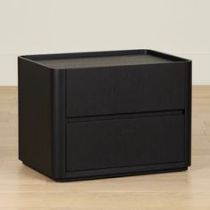 a black file cabinet sitting on top of a hard wood floor