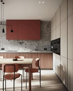 a modern kitchen with red cabinets and marble counter tops, along with a dining table