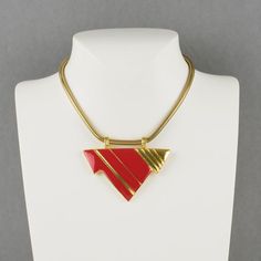 Lovely Lanvin Paris modernist pendant choker necklace. Serpentine gilt metal chain ornates with geometric pendant in shiny gilt metal and red enamel. Spring ring-closing clasp. Signed with a little gilded tag underside the pendant: "Lanvin - Paris." Measurements: total length 15.38 in (39 cm) - pendant: 2.88 in wide x 2.38 in high (7.3 x 6 cm).  Please see the measurements noted above, in the description for the best approximate dimensions. Formal Red Enamel Necklaces, Formal Red Enamel Necklace, Red Metal Necklace With Large Pendant, Formal Red Necklace With Large Pendant, Red Necklace With Large Pendant For Formal Occasions, Red Enamel Jewelry With Large Pendant, Red Enamel Collectible Jewelry, Modern Gold Collectible Jewelry, Modern Gold Jewelry For Collectors