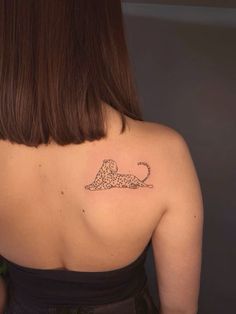 the back of a woman's shoulder with a leopard tattoo on her left arm